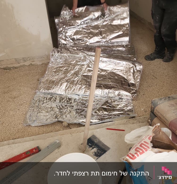 אדם פורש יריעות בידוד על רצפה